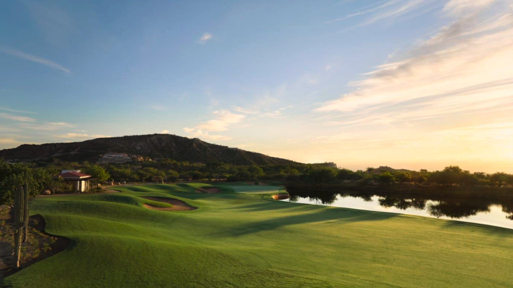 One&Only Palmilla Golf Club course at sunset, with fairways, bunkers, a water feature, and desert hills in the background.